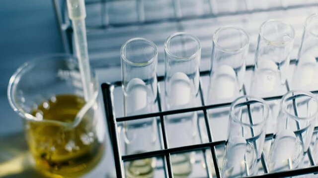 The scientist dropping the chemical solution in test tube in the laboratory experiment. Chemical and Oil concept