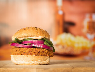 A spicy bean burger on a seeded bun with spinach and red onion in a restaurant setting