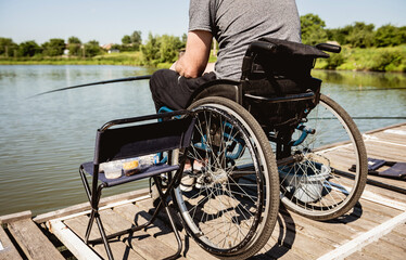 Obraz premium Young disabled man in a wheelchair fishing.