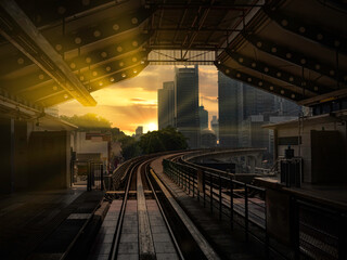 Going to work by train under a bright sunny sunrise with the cityscape and building at the horizon