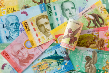 Money from Costa Rica. The highest face value of 20,000 colones rolled up against the background of other banknotes of this country