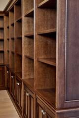 Wooden bookcase with empty shelves in home library