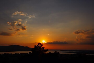 Colorful Sunset with Clouds and Tree Silhouette in Palava Protected Landscape Area with Nove Mlyny Reservoirs in the Distance. Sun Goes Down in South Moravia.