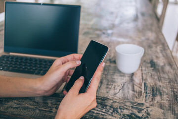 Faceless woman messaging on smartphone