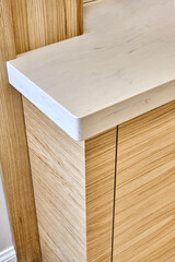 Wooden kitchen cupboard with acrylic solid surface countertop. Close-up