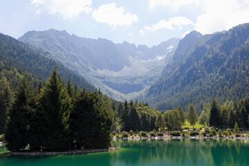 Fototapeta na wymiar Cloudy sky on Alps with a little lake, summer time 