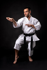 Fototapeta na wymiar karateka practicing kata with black background