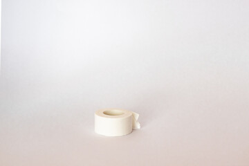 A small adhesive plaster lies in the center on a white background