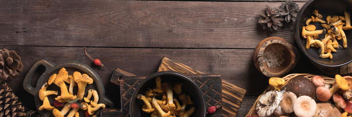 Autumn harvest of mushrooms on vintage rustic wooden background. Rustic kitchen table. Flat lay top, top view . Layout with free text space. Forest harvest concept. Banner.