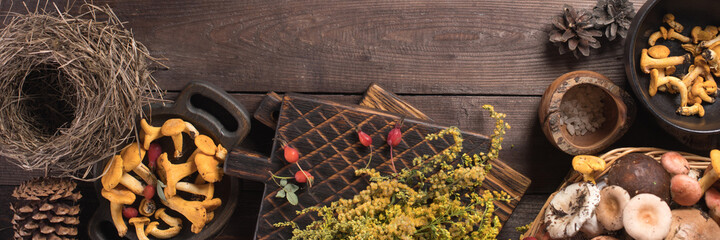 Autumn harvest of mushrooms on vintage rustic wooden background. Rustic kitchen table. Flat lay top, top view . Layout with free text space. Forest harvest concept. Banner.