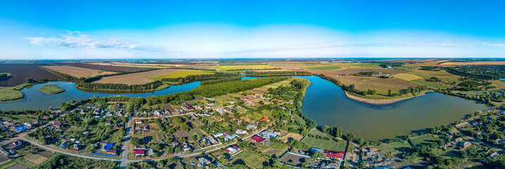 aerial panorama of the south-western outskirts of the village of Sergievskaya (South of Russia) and the Kirpili river on a sunny summer day