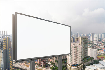 Fototapeta premium Blank white road billboard with KL cityscape background at day time. Street advertising poster, mock up, 3D rendering. Side view. The concept of marketing communication to promote or sell idea.