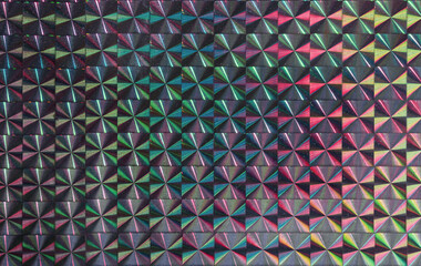 real hologram background of abstract foil texture with multiple glitter colors. Neon pastel and rainbow colors. Disco motion concept background. Full frame macro.