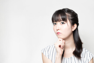 顎に手を添えて考えている女性