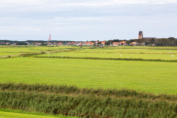 Fototapeta na wymiar Lighthouse in a rural landscape on an island in the North Sea, Ameland, Holland
