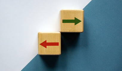 Conceptual image of choice and direction. Wooden cubes with arrows pointing in opposite directions....