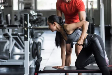 Tuinposter Personal trainer coach Dumbbell on bench to girl © Blanscape