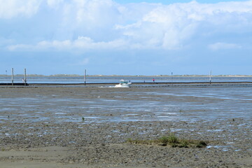 a view over the Wadden Sea from Neßmersiel to Norderney, with a boat in the foreground