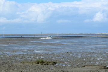 a view over the Wadden Sea from Neßmersiel to Norderney, with a boat in the foreground
