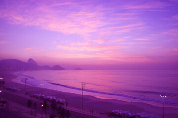 Fototapeta na wymiar Pop art surreal style purple colored Copacabana beach at sunset, Rio de Janeiro, Brazil