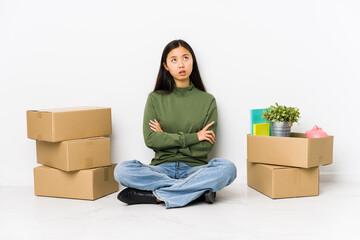 Young chinese woman moving to a new home tired of a repetitive task.