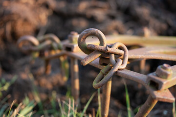 Hook and chain on an old metal harrow