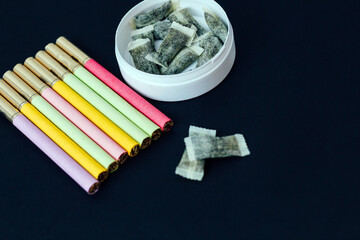 Round box of snus with multicolored cigarettes Cigarette substitute, nicotine pouches.