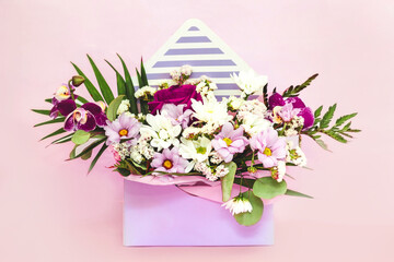 Box in the form of an envelope with a bouquet of flowers. Orchids, greenery, chrysanthemums and rose.