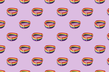Lgbt bracelet on lilac background, pattern. The concept of sexual tolerance, stop homophobia, same-sex relationships, homosexuality. Long horizontal banner.