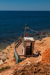 Old abandoned wooden ship stands on the seashore