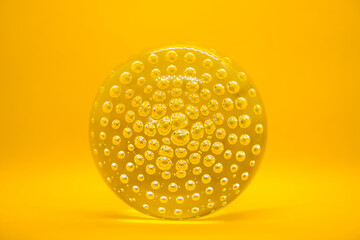 Glass ball with bubbles on yellow background isolated