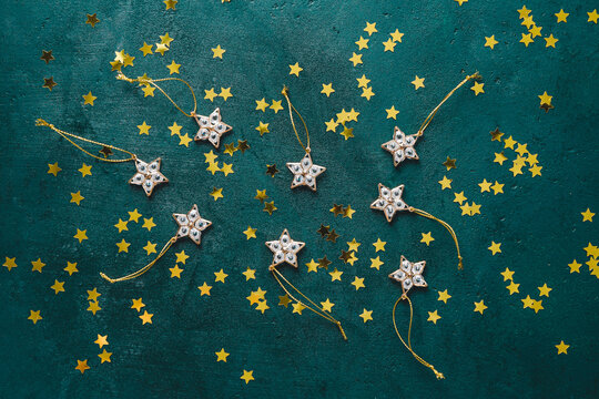 The New Year or Christmas festive flat lay with golden stars over a dark green background. Top view, copy space. © Edalin