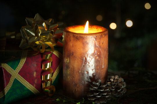 Christmas candle burning with gifts and decorations.