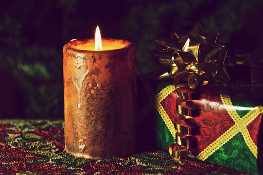 Christmas candle burning with gifts and decorations.