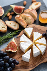 Camembert cheese plate with grapes, figs, honey and baguette. Cheese platter