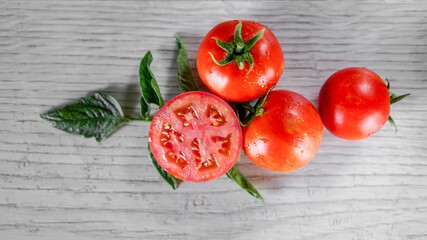 Tomatoes on white kitchen and tomato juice with green tomato leaves. Home grown tomatoes 