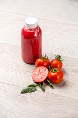 Tomatoes on white kitchen and tomato juice with green tomato leaves. Home grown tomatoes 
