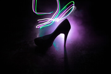Silhouette of a high heel women shoes at dark. Women power or women domination concept.