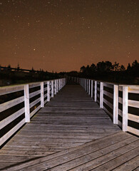 Night photography with long exposure. Wooden bridge, and clear sky.