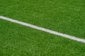Green synthetic grass sports field with white line shot from above. Soccer, rugby, football, baseball sport concept