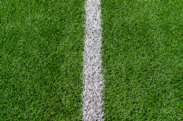 Fototapeta premium Green synthetic grass sports field with white line shot from above. Soccer, rugby, football, baseball sport concept