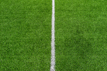 Fototapeta premium Green synthetic grass sports field with white line shot from above. Soccer, rugby, football, baseball sport concept