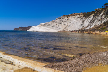 Limestone white cliffs with beach and swimmers at the Scala dei Turchi (Stair of the Turks) near Realmonte, Sicily, Italy