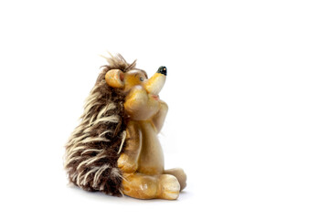 Isolated ceramic toy for children pensive hedgehog sitting side view on white background space for text