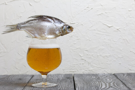 A glass of beer. There is a roach on the glass.
