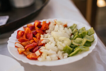 pepper and onion on a white plate to prepare a typical Spanish seafood paella