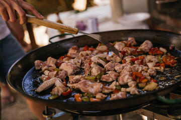 Chicken and garnish for Spanish paella resting in black paella pan