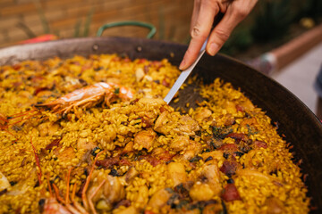 Young woman serving a serving of typical Spanish seafood paella