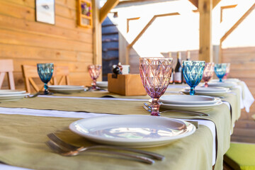 Banquet table setting with white plates, glass glasses.