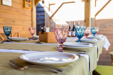 
Banquet table setting with white plates, glass glasses.